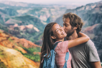 Couple in love kissing on nature travel hiking in Hawaii mountains. Young hikers people happy...
