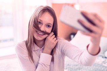 Nice smiling teenager having fun doing selfies