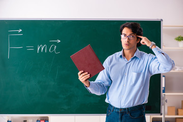 Young male physic standing in front of the green board