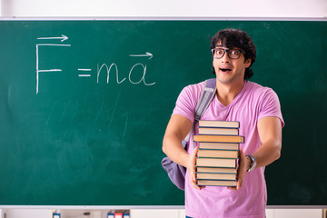 Young male physic standing in front of the green board