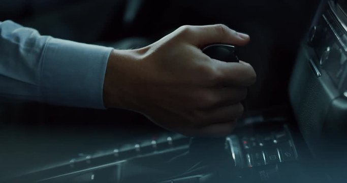 Close up young businessman is driving a new car just bought from auto deal. Slow motion shot in 8K. Concept of passion for driving cars and engines, car dealerships, used cars, luxury cars