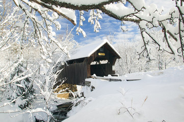 Covered bridged blanketed in fresh snow on a sunny winter morning.