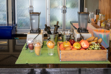 Blender machines and fruits in kitchen space in restaurant