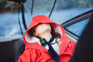 beautiful young woman in a red raincoat rides a private yacht. Stockholm, Sweden © Yuliya Kirayonak