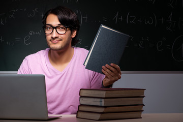 Young male student sitting in classroom