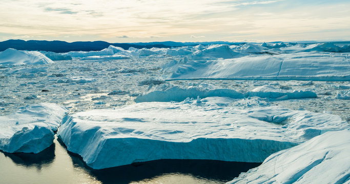 Climate Change and Global Warming - Icebergs from melting glacier in icefjord in Ilulissat, Greenland. Aerial image of arctic nature ice landscape. Unesco World Heritage Site.