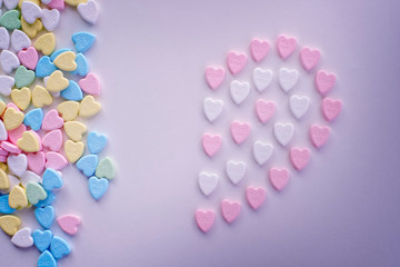 Valentine half pink heart candies with piles of pastel colourful candies