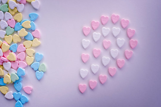 Valentine half pink heart candies with piles of pastel colourful candies