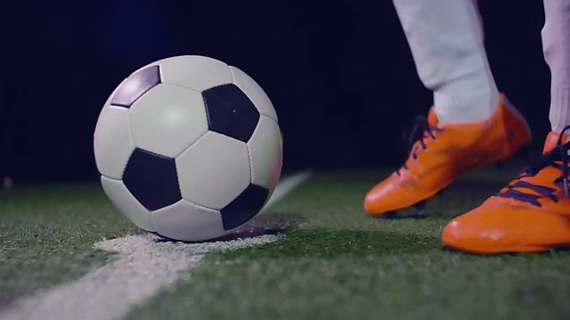 Professional soccer player putting his boot on the ball in the center point of the field, 4k slow motion