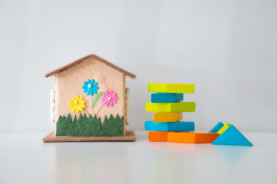 Miniature house with tangram puzzle on white background using as property real estate investment, education and family concept