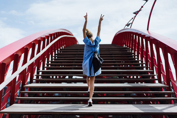 beautiful girl in a blue dress posing on the bridge