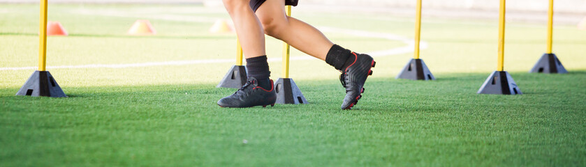 soccer player Jogging and jump between marker and yellow hurdles.