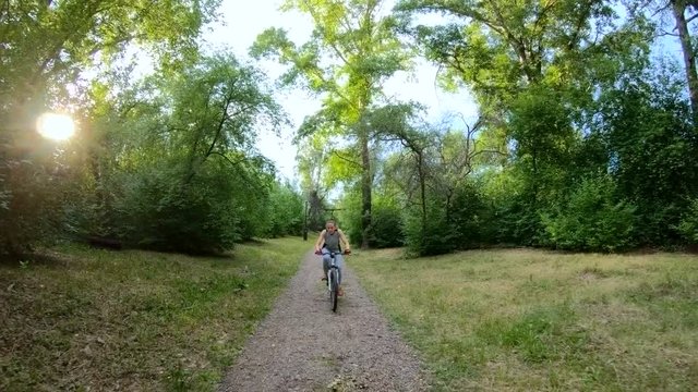 Cycling in the park. Girl riding a bike on a forest trail. Front view. Slow motion