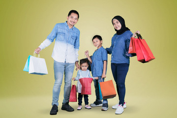 Asian family holding shopping bags on studio