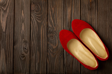 Red women's shoes (ballerinas) on wooden background.