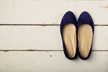 Blue women's shoes (ballerinas) on wooden background.
