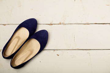 Blue women's shoes (ballerinas) on wooden background.
