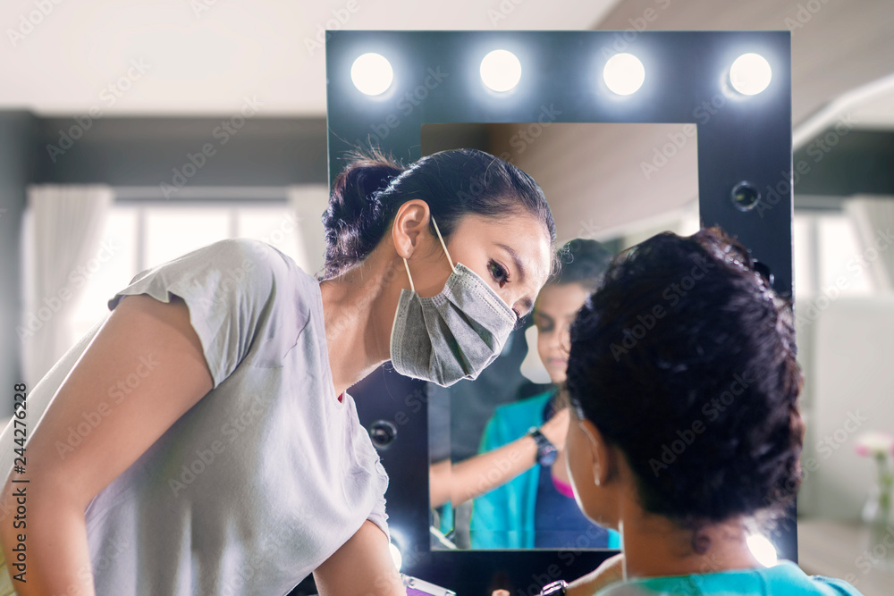 Wall mural makeup artist prepares her client before the wedding