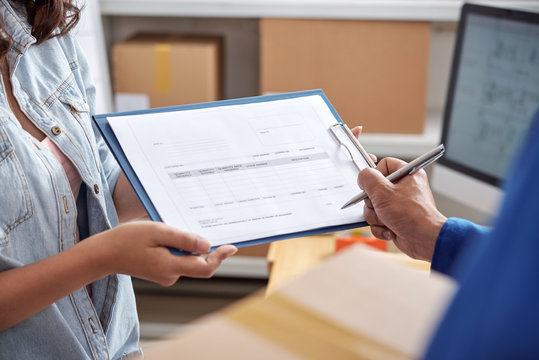 Delivery service manager asking courier to sign document after taking order
