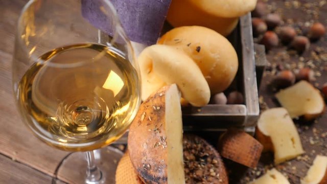 Closeup shot of red wine in glass and set of fresh delicious cheese placed in wooden box. Wine and cheese concept. Luxury restaurant concept. Food art. hd