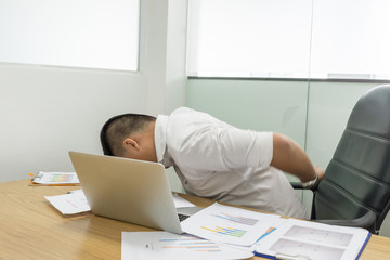 Asian Office employee feels backache in the business room