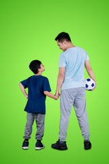Fototapeta premium Young man holding a soccer ball with his son