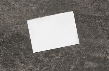 White paper placed on grey concrete floor with spaces for text.