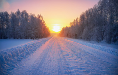 Sun over siberian rural empty road under the snow at morning time