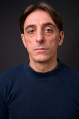 Obraz premium Face of mature handsome Italian man against gray background