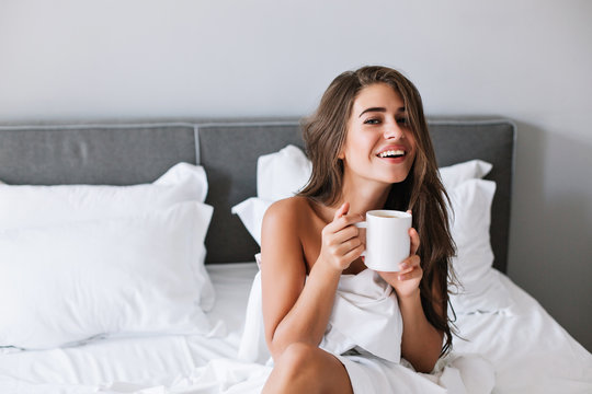 Portrait Pretty Girl With Naughty Shoulders Drinking Coffee On Bed In The Morning In Apartment