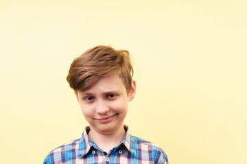 smug cheeky daring boy with skeptical smile over yellow background, advertisement, banner or poster...