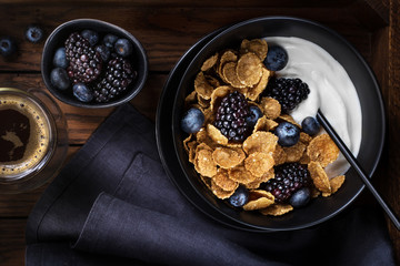 Whole wheat flakes, blackberries, blueberries and natural yogurt, top view, flat lay 