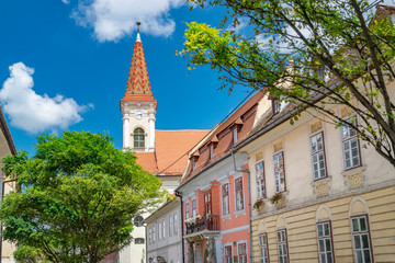 Fototapeta premium Sibiu, Romania - Beautiful street with Reformed Church on a sunny summer day in Sibiu, Romania