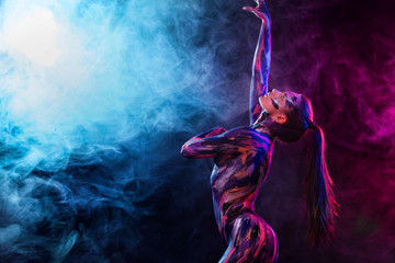 Junge Frau malte verschiedene Farben. Inspirierter Tanz zur Musik. Körperkunst bunt. Eine erstaunliche Frau mit Kunstmode-Make-up.