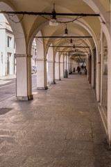 historical covered walkway in town center, Brescia, Italy