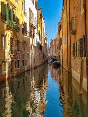 small canal in the city of venice with narrow houses