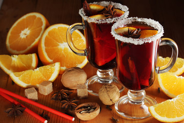 Two cups with ready mulled wine with anise, cinnamon and nuts around