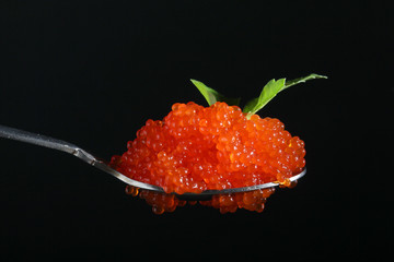 A spoon with red caviar	