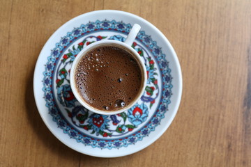 a cup of turkish coffee on a wooden table
