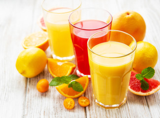 Glasses of juice and citrus fruits