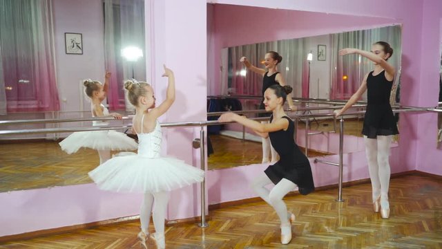 Elegant ballerinas are in modern ballet studio. Beautiful ballerinas in black tutus at a ballet lesson.