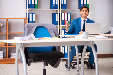 Young handsome employee working in the office  