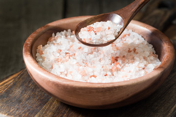 Sea pink salt in a wooden bowl on a wooden table. Rustic style