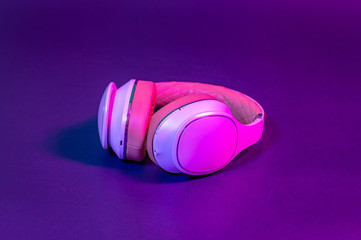 White headphones on dark background. Neon style.