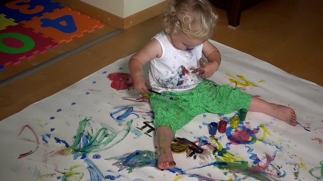 Funny toddler child with colored face painting on his clothes