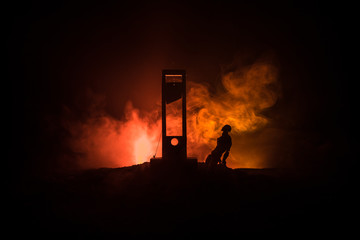 Horror view of Guillotine. Close-up of a guillotine on a dark foggy background.