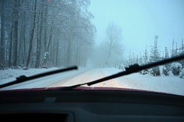 Driving the car in the winter. View from the interior of a car on a snowy road by the eyes of the driver. Concept for driving safety in the winter.
