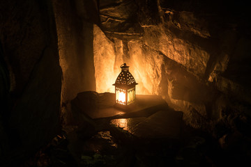 Fototapeta na wymiar Beautiful colorful illuminated lamp in the garden in misty night. Retro style lantern at night outdoor.