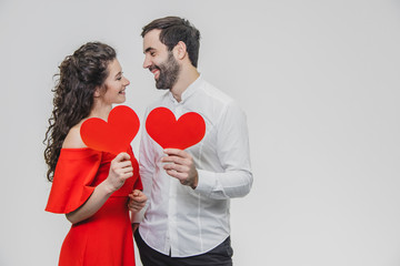 Beautiful attractive, cheerful, positive pair. Are married Hold large red cards in their sleeves. When they look at each other.