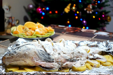Pickled carp prepared for baking lies on the foil for the holiday table.